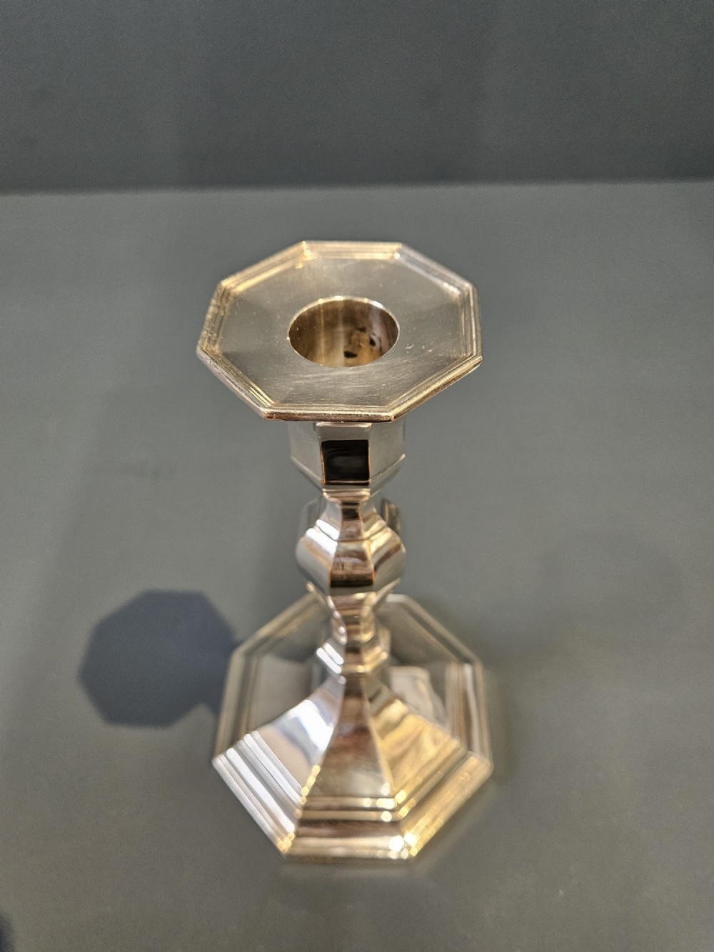 A pair of polished silver candlesticks featuring octagonal faceted bases and baluster stems. View III