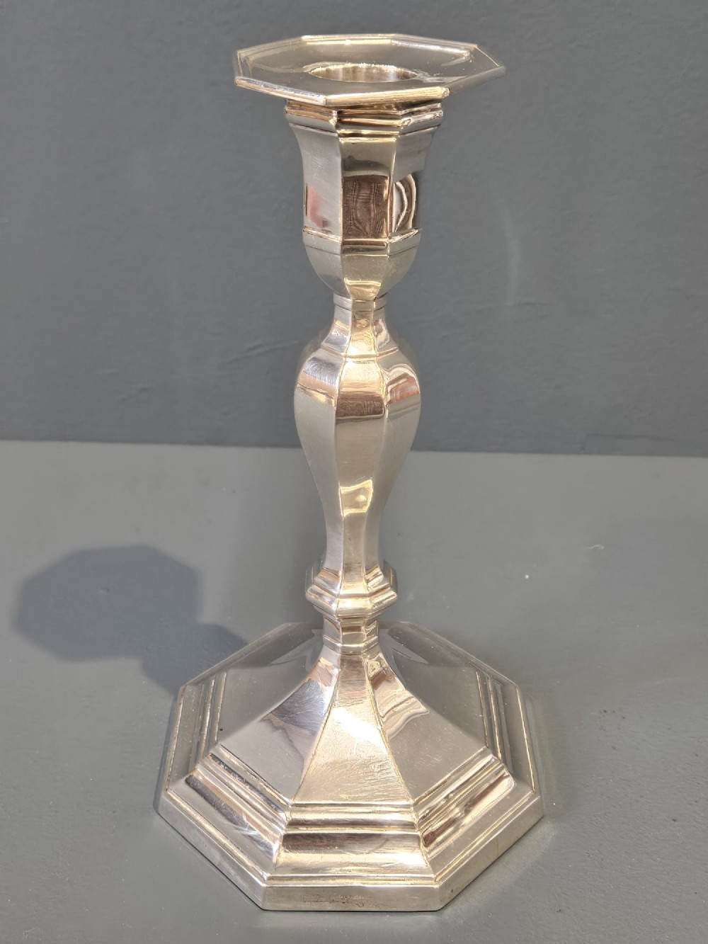A pair of polished silver candlesticks featuring octagonal faceted bases and baluster stems. View IV