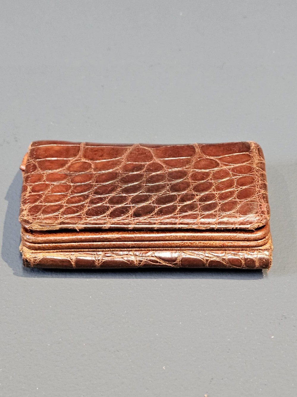 A small rectangular brown crocodile skin purse with hallmarked sterling silver rim mounts and a central push-button clasp. View V