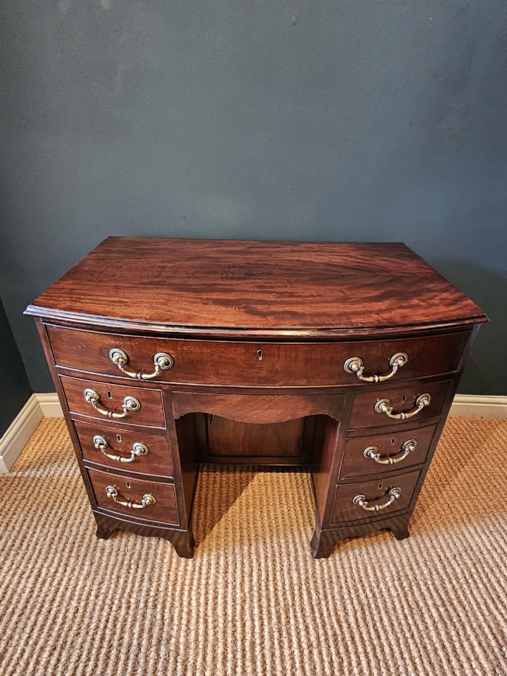 An 18th-century George III mahogany secretaire dressing chest featuring a kneehole configuration, multiple drawers with brass handles, and a central cupboard. View II