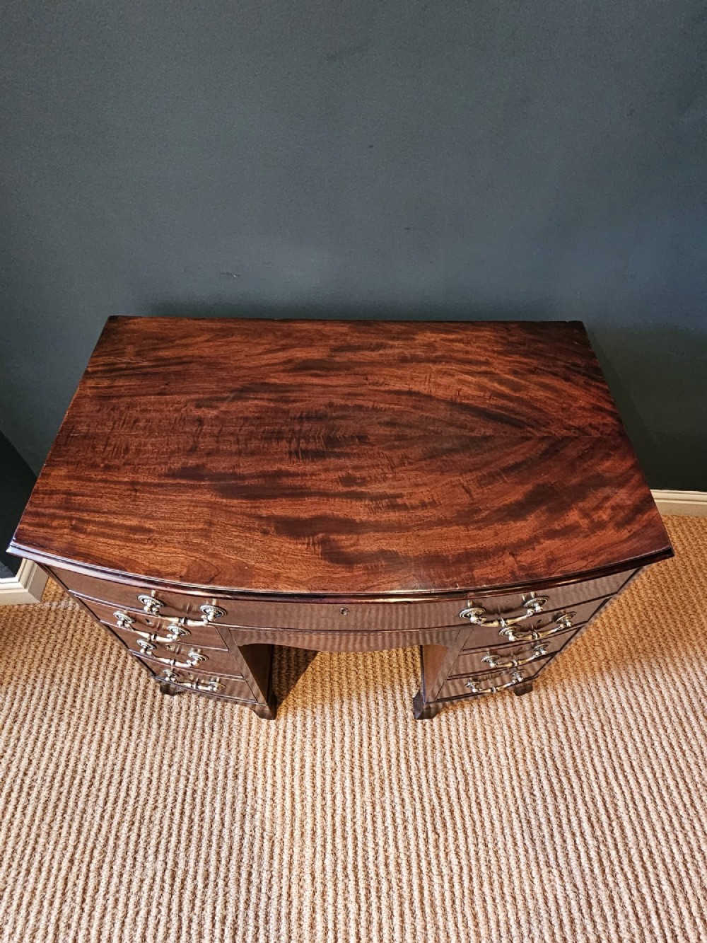 An 18th-century George III mahogany secretaire dressing chest featuring a kneehole configuration, multiple drawers with brass handles, and a central cupboard. View III
