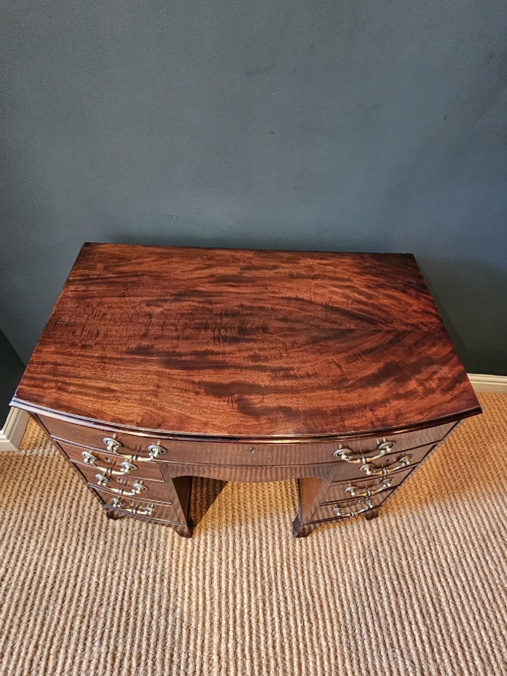 An 18th-century George III mahogany secretaire dressing chest featuring a kneehole configuration, multiple drawers with brass handles, and a central cupboard. View V