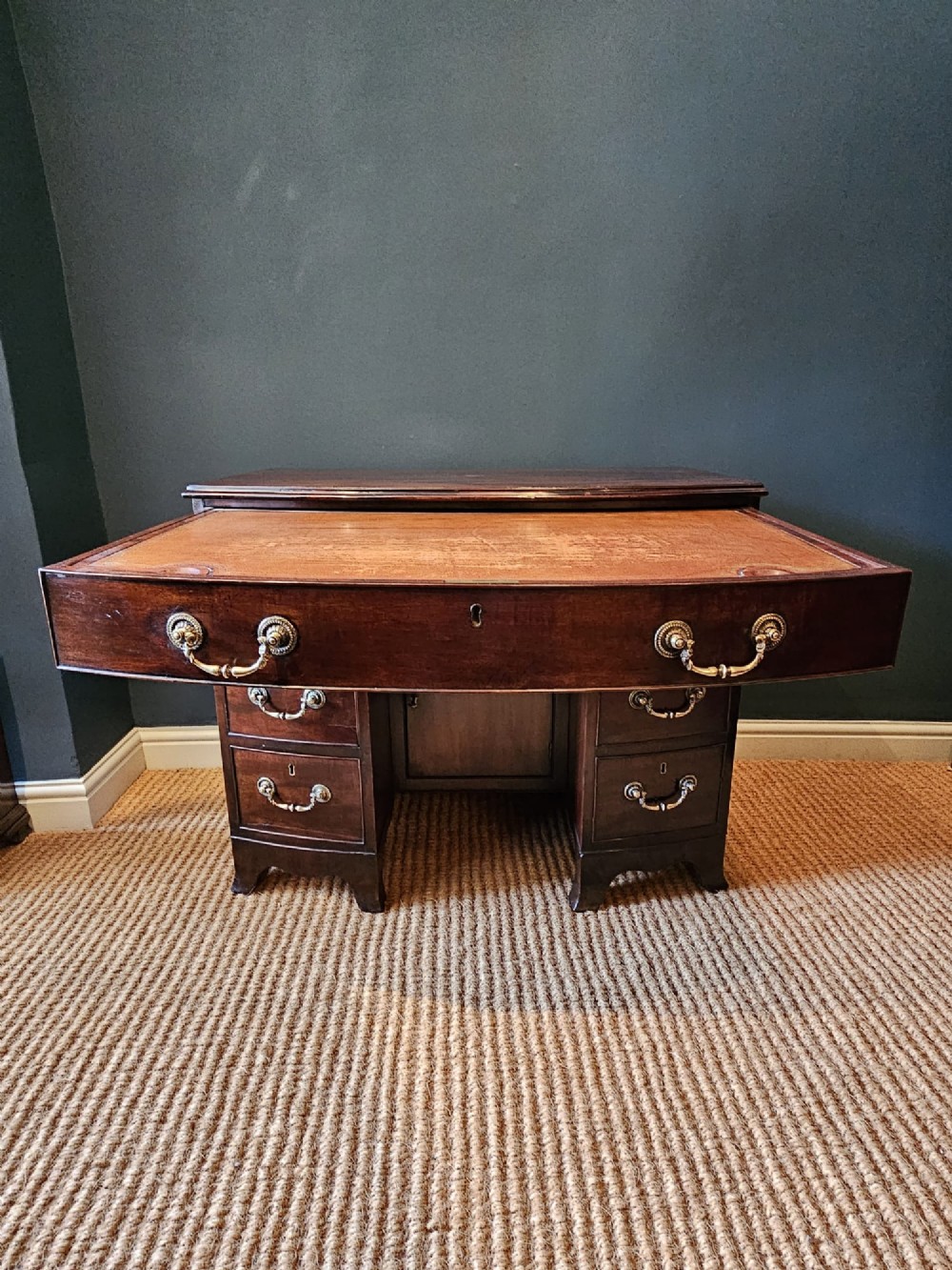 An 18th-century George III mahogany secretaire dressing chest featuring a kneehole configuration, multiple drawers with brass handles, and a central cupboard. View VI