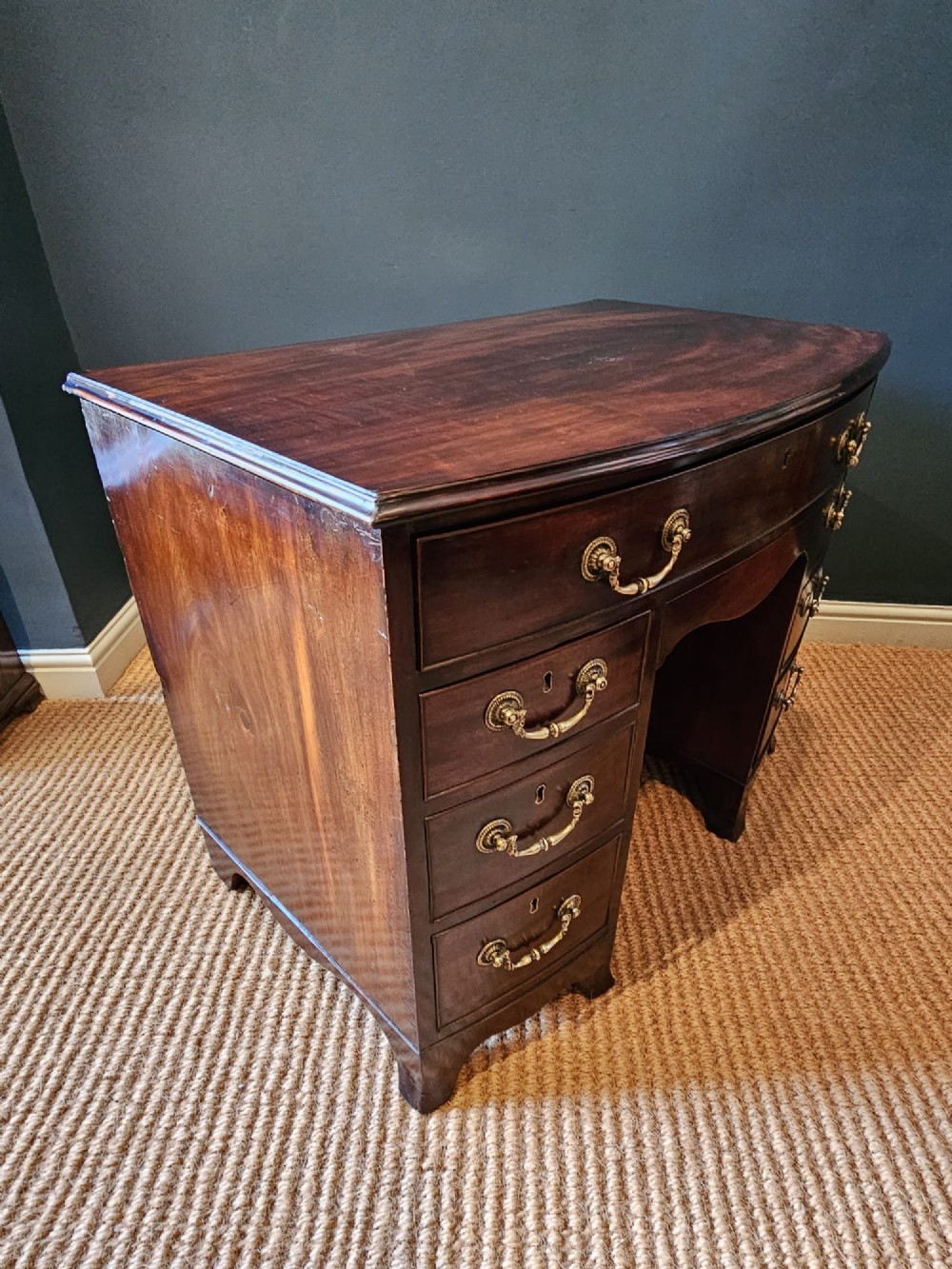 An 18th-century George III mahogany secretaire dressing chest featuring a kneehole configuration, multiple drawers with brass handles, and a central cupboard. View VIII