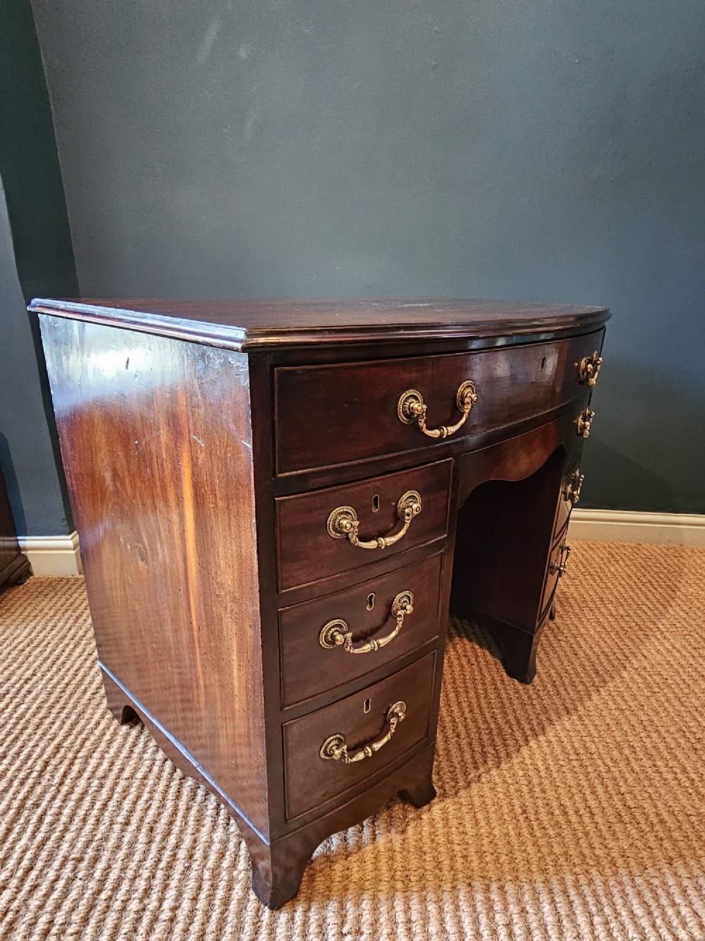 An 18th-century George III mahogany secretaire dressing chest featuring a kneehole configuration, multiple drawers with brass handles, and a central cupboard. View IX