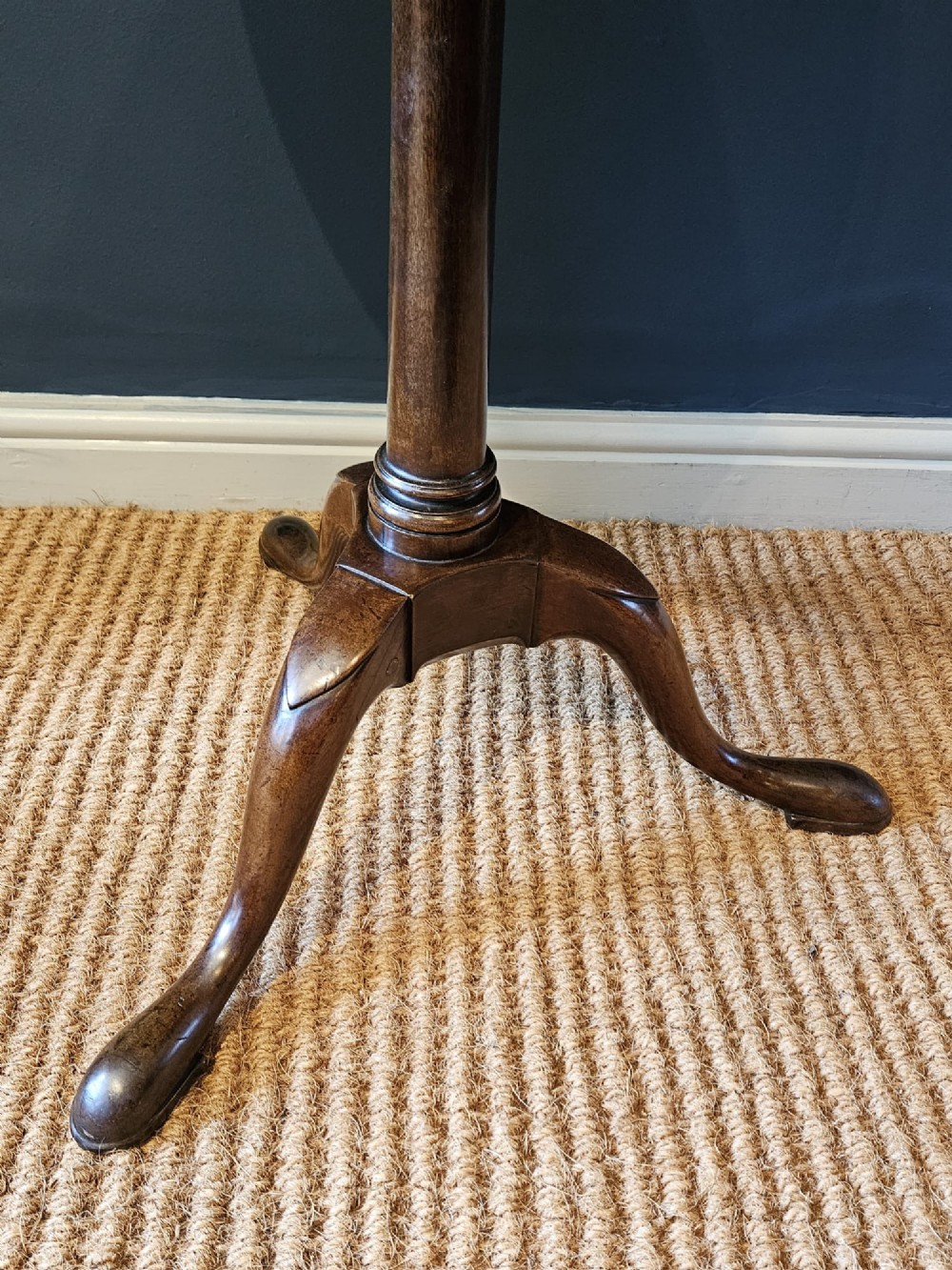 A George II red walnut tripod table featuring a circular dished top set upon a turned central column and three cabriole legs with pad feet. View VI