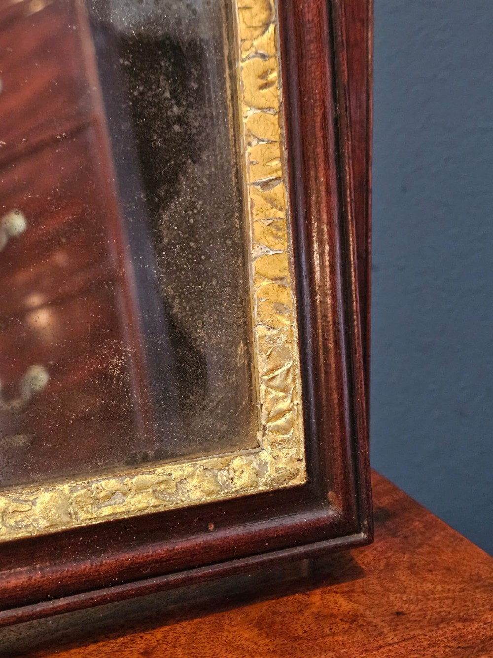 A George II mahogany toilet mirror featuring a swivelling glass plate with a gilded interior moulding, supported on vertical uprights above a drawer base. View V