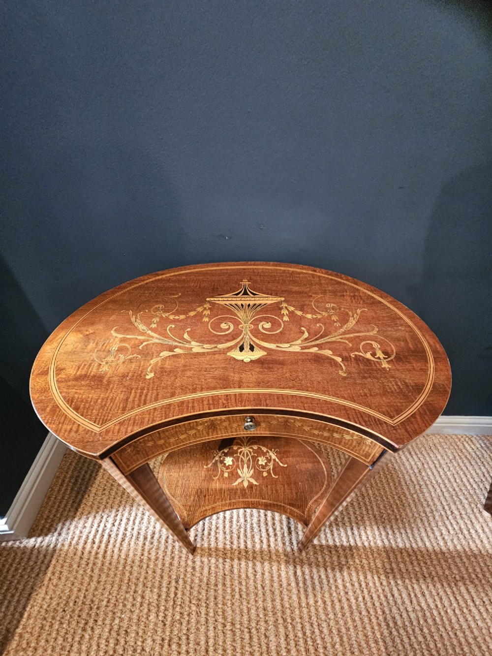 An Edwardian kidney-shaped mahogany occasional table featuring classical marquetry inlay, a single drawer, and an undertier shelf supported by slender tapered legs. View II