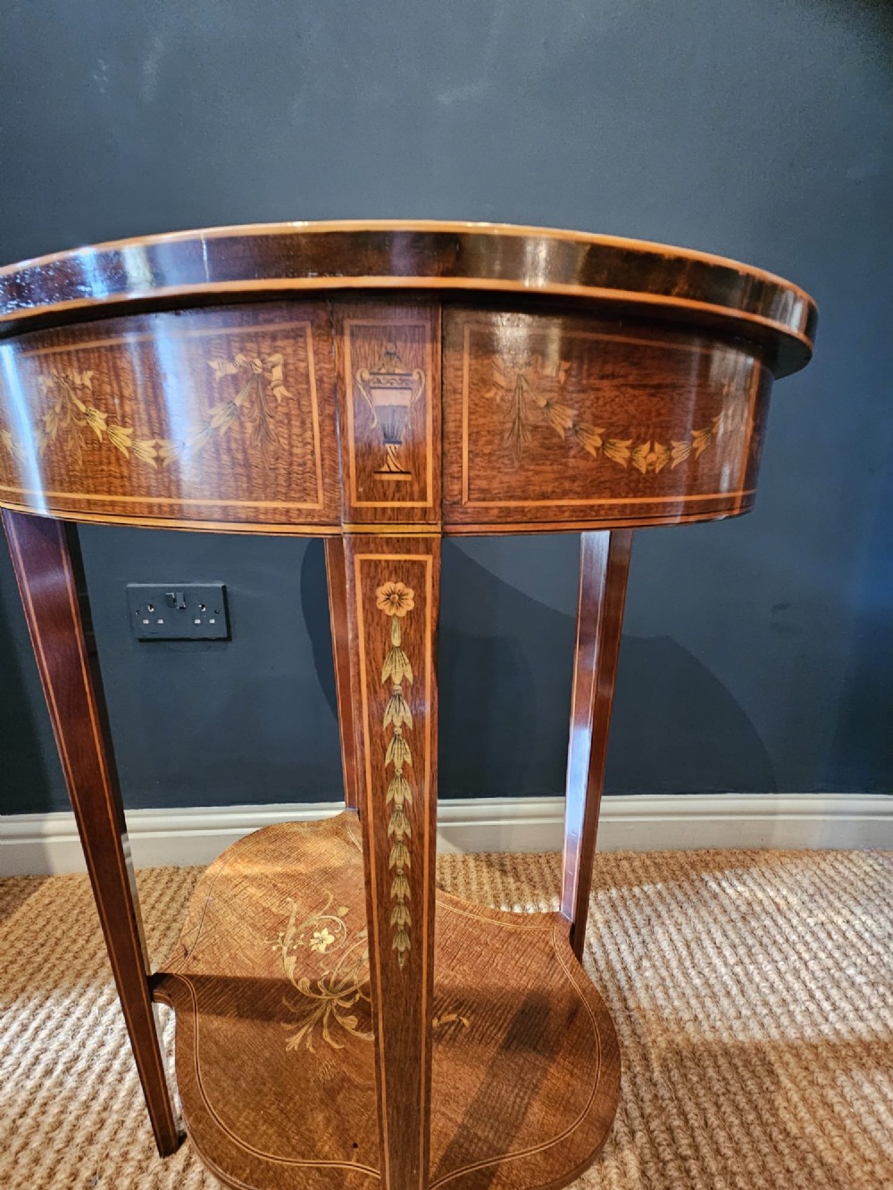 An Edwardian kidney-shaped mahogany occasional table featuring classical marquetry inlay, a single drawer, and an undertier shelf supported by slender tapered legs. View IX