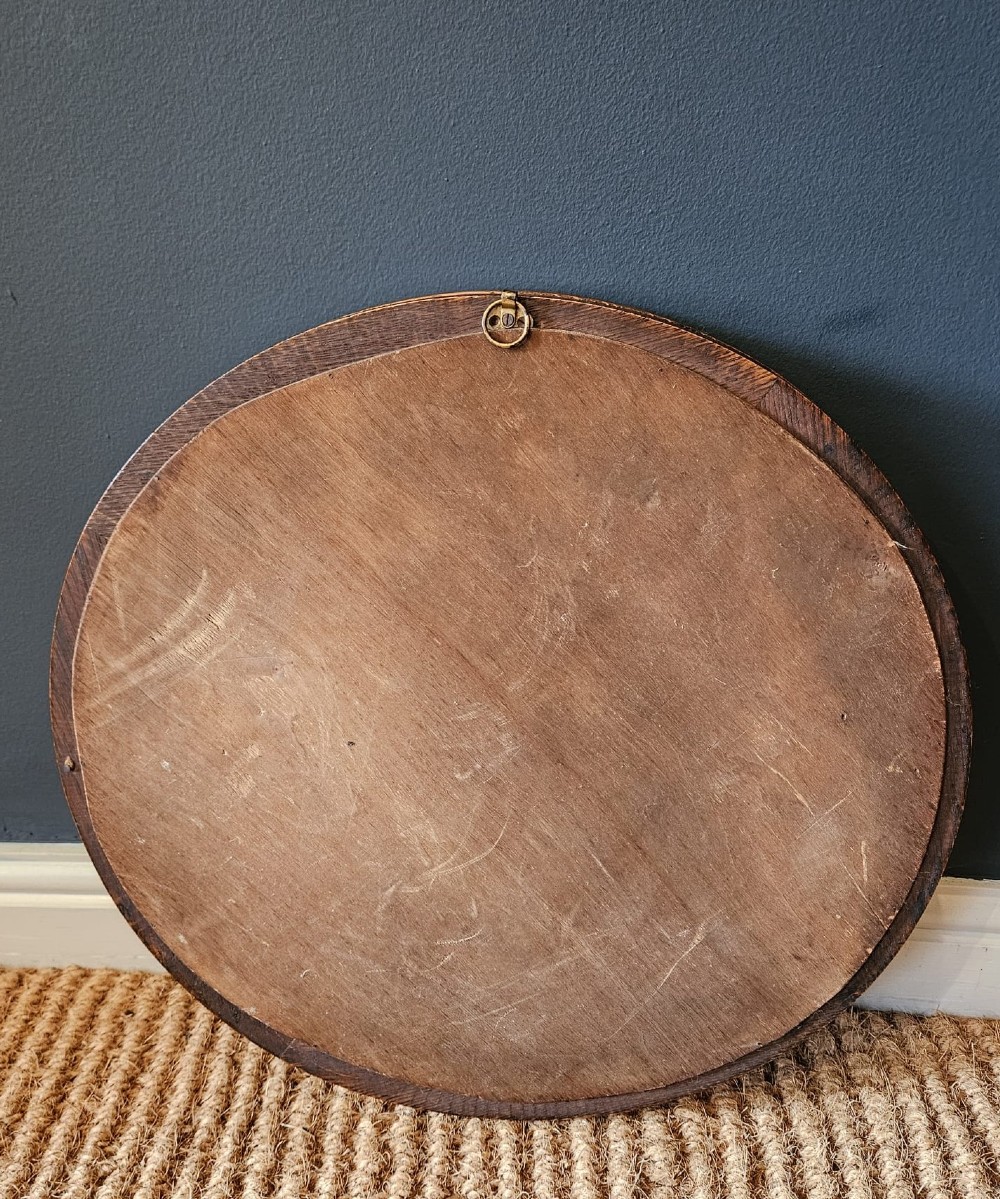 A circular Edwardian oak framed convex mirror featuring a raised moulded border inset with evenly spaced turned wooden spheres. View II