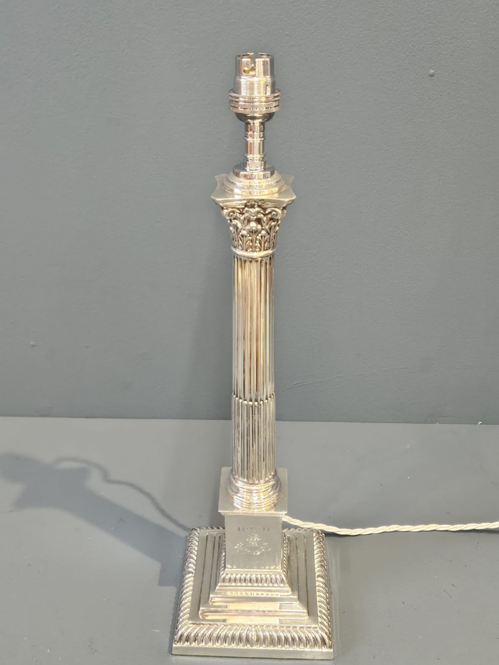 A Victorian silver Corinthian column table lamp with an acanthus leaf capital, fluted shaft, and engraved stepped base. View IV