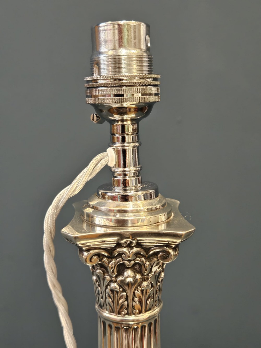 A Victorian silver Corinthian column table lamp with an acanthus leaf capital, fluted shaft, and engraved stepped base. View V