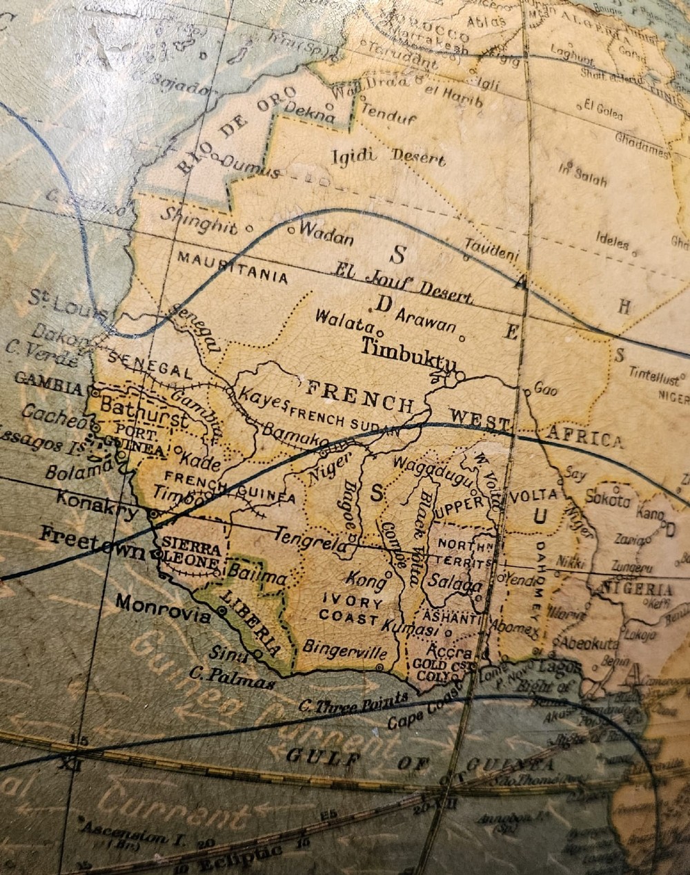 A 1920s terrestrial table globe with printed paper maps mounted on a brass semi-meridian arc and a turned dark walnut base. View V