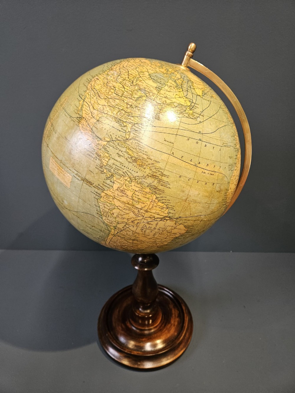 A 1920s terrestrial table globe with printed paper maps mounted on a brass semi-meridian arc and a turned dark walnut base. View IX