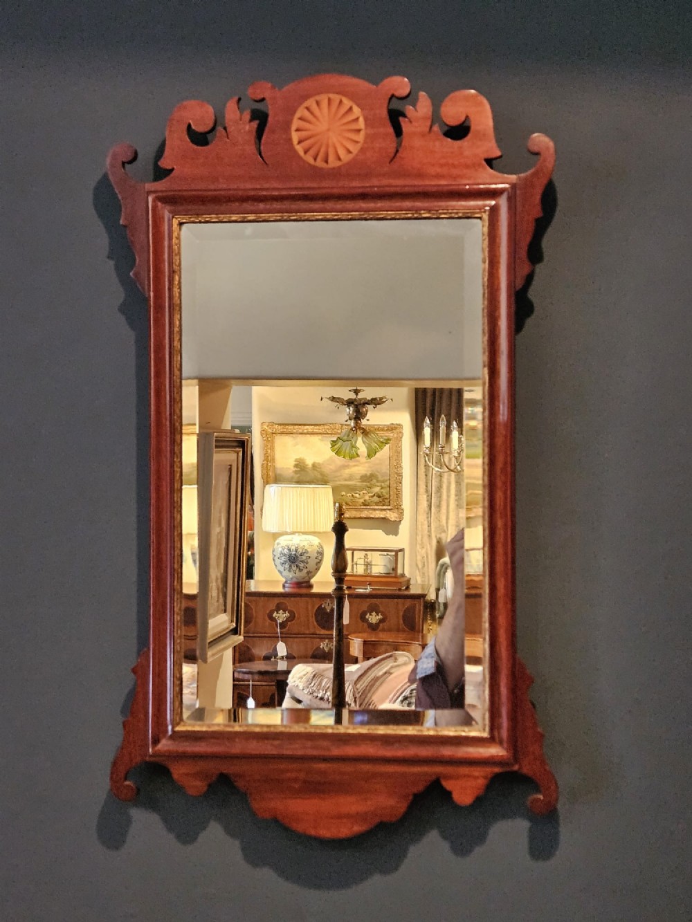 A George III mahogany fretwork wall mirror featuring a scrolled cresting with an inlaid patera roundel, a gilded sight edge, and a rectangular mirror plate. View VI