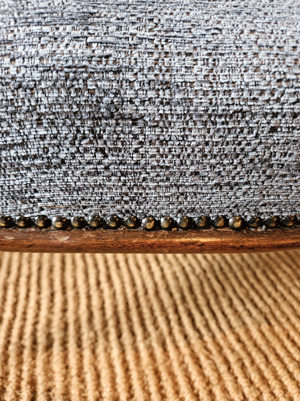A Victorian double stool featuring dark carved wooden legs and textured light blue fabric upholstery secured with metal studding. View V