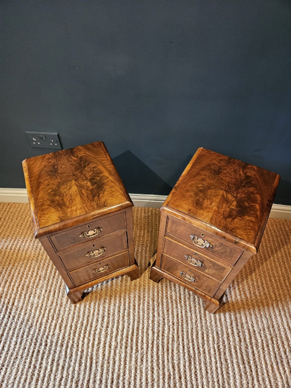 A matching pair of Victorian walnut bedside chests with three drawers, brass drop handles, and bracket feet. View II