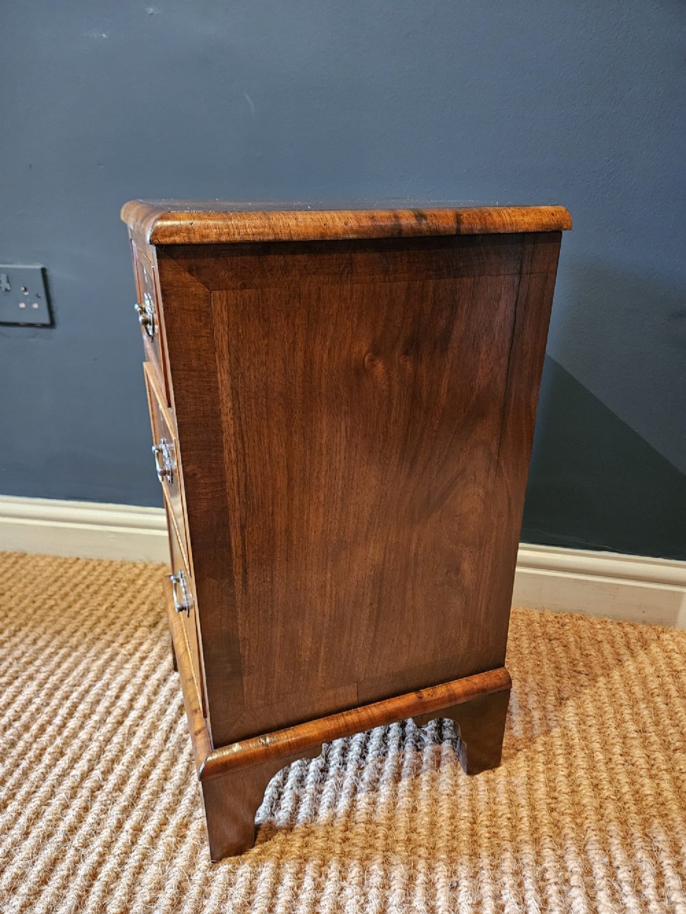 A matching pair of Victorian walnut bedside chests with three drawers, brass drop handles, and bracket feet. View VI