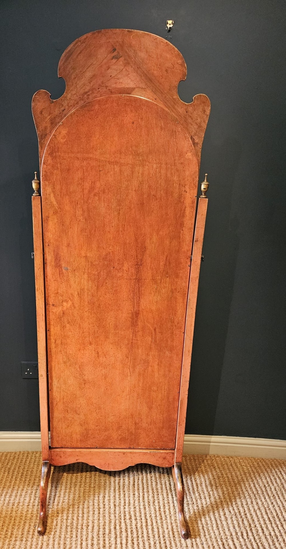 A tall 1920s Chinoiserie freestanding cheval mirror featuring an arched frame decorated with gold hand-painted Asian figures and landscapes on a warm terracotta lacquered background. View XI