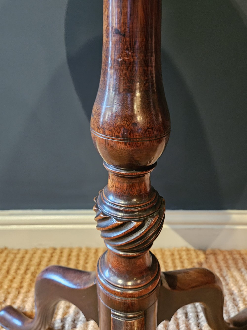 A George III mahogany snap top tripod table featuring a circular dished top, turned column with spiral detailing, and splayed cabriole legs. View III