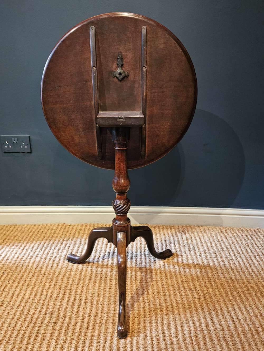 A George III mahogany snap top tripod table featuring a circular dished top, turned column with spiral detailing, and splayed cabriole legs. View VIII