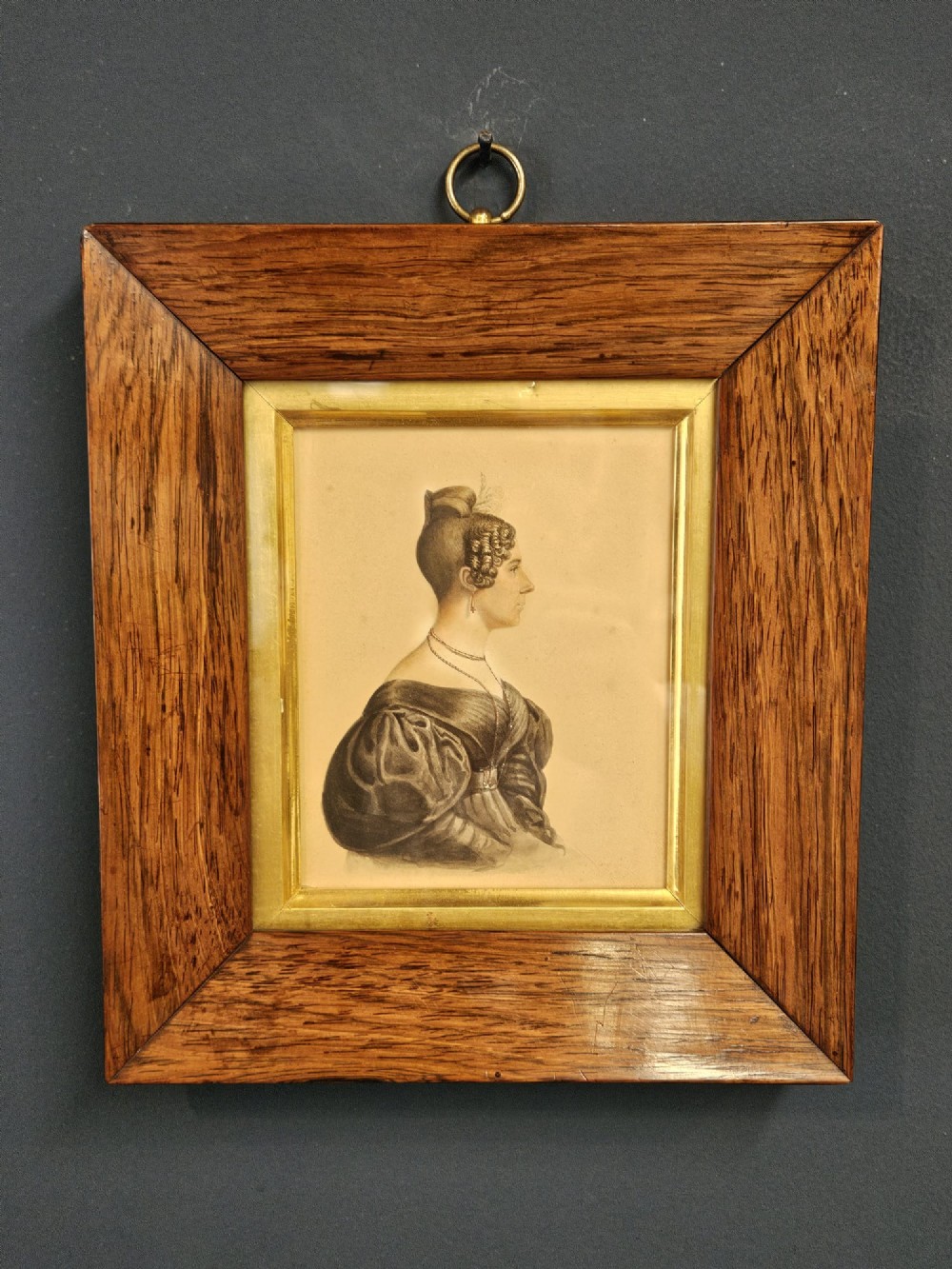 A pair of early Victorian profile portrait miniatures depicting a gentleman and a lady, presented in matching rosewood frames with gilt slips and brass hanging rings. View V
