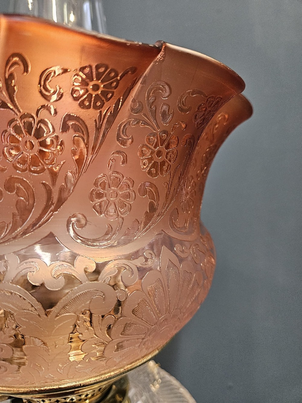 A Victorian oil lamp featuring a stepped brass base, fluted Corinthian column stem, cut crystal reservoir, etched pink glass shade, and clear glass chimney. View V