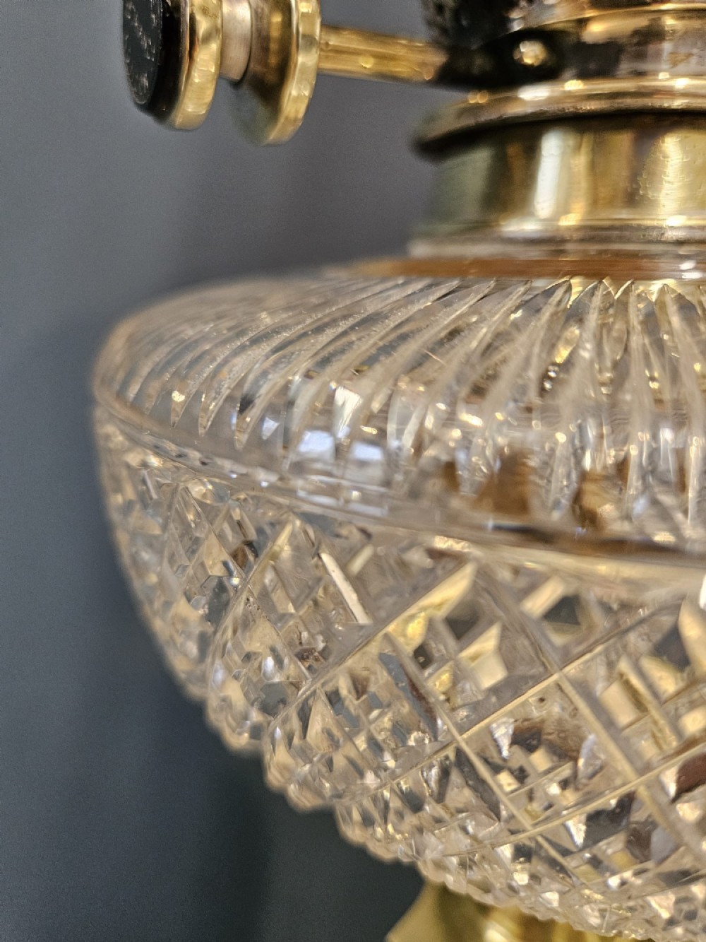 A Victorian oil lamp featuring a stepped brass base, fluted Corinthian column stem, cut crystal reservoir, etched pink glass shade, and clear glass chimney. View VII