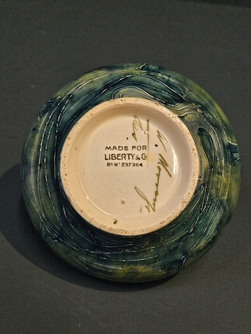 A squat ceramic Art Nouveau vase featuring a hand-painted tube-lined tree motif in shades of teal blue and green over a soft yellow background. View VII