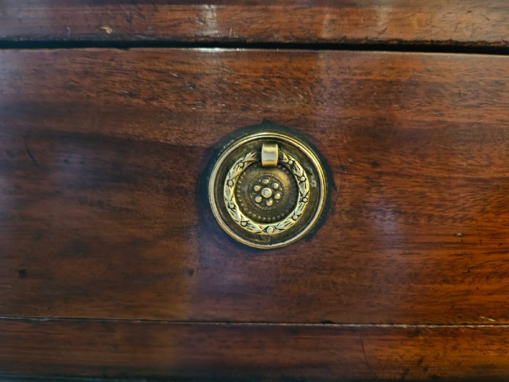 An antique Victorian mahogany pedestal desk with a tan leather writing surface, nine drawers fitted with brass handles, and solid plinth bases. View II