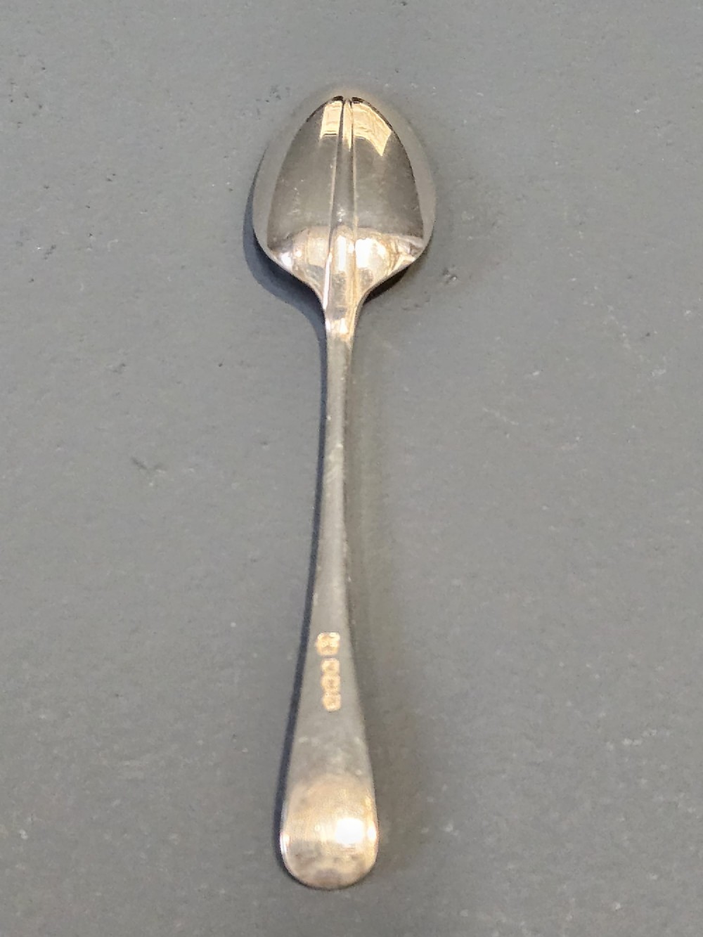 A cased set of twelve sterling silver teaspoons and matching sugar tongs displayed inside a dark blue velvet and cream satin lined box. View III