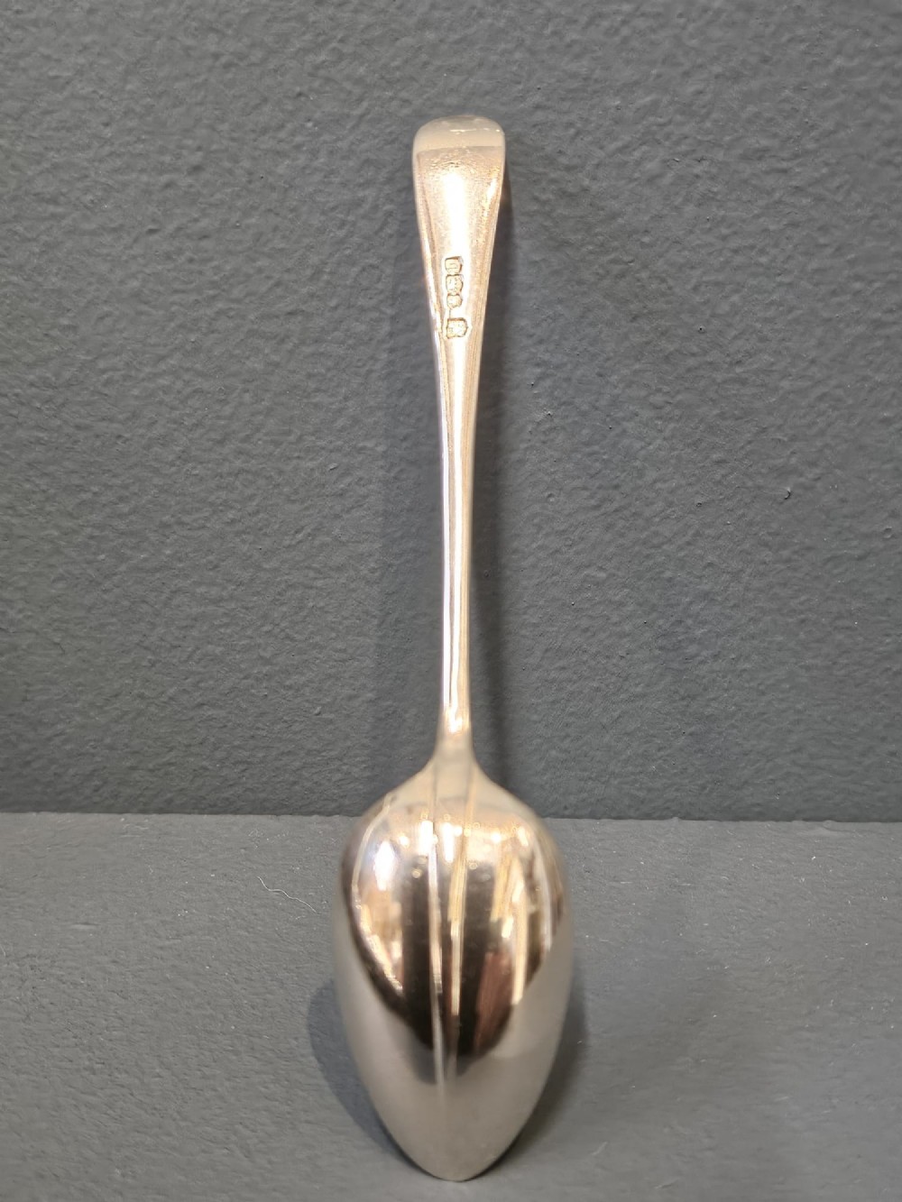 A cased set of twelve sterling silver teaspoons and matching sugar tongs displayed inside a dark blue velvet and cream satin lined box. View VII