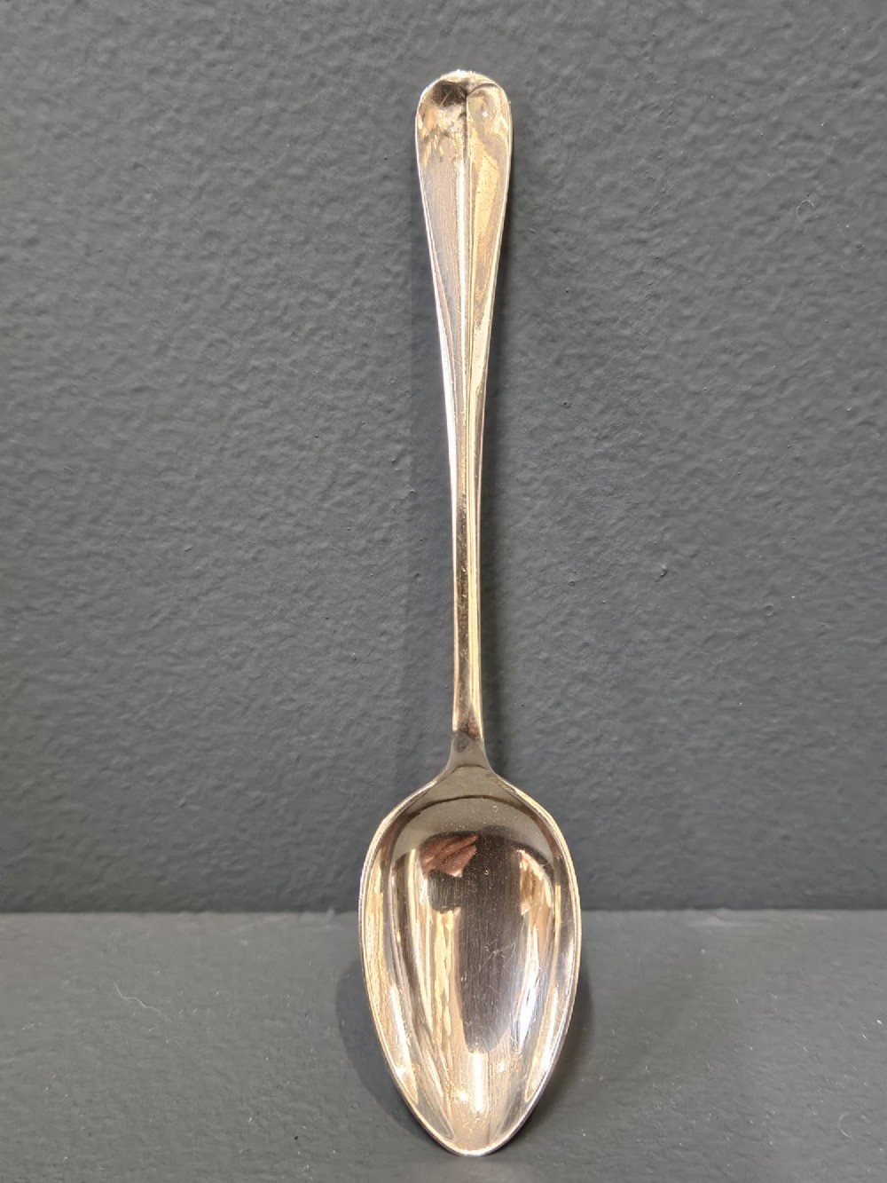 A cased set of twelve sterling silver teaspoons and matching sugar tongs displayed inside a dark blue velvet and cream satin lined box. View X