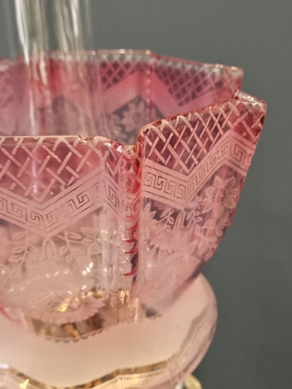 A Victorian brass oil lamp featuring a stepped square base, fluted Corinthian column, cut glass reservoir, and a flared etched cranberry glass shade. View VIII