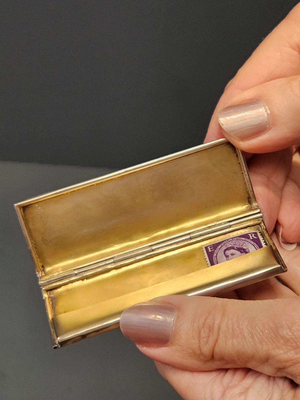 A slim rectangular silver box featuring intricate engraved foliate scrollwork and a central unengraved shield cartouche. View VII