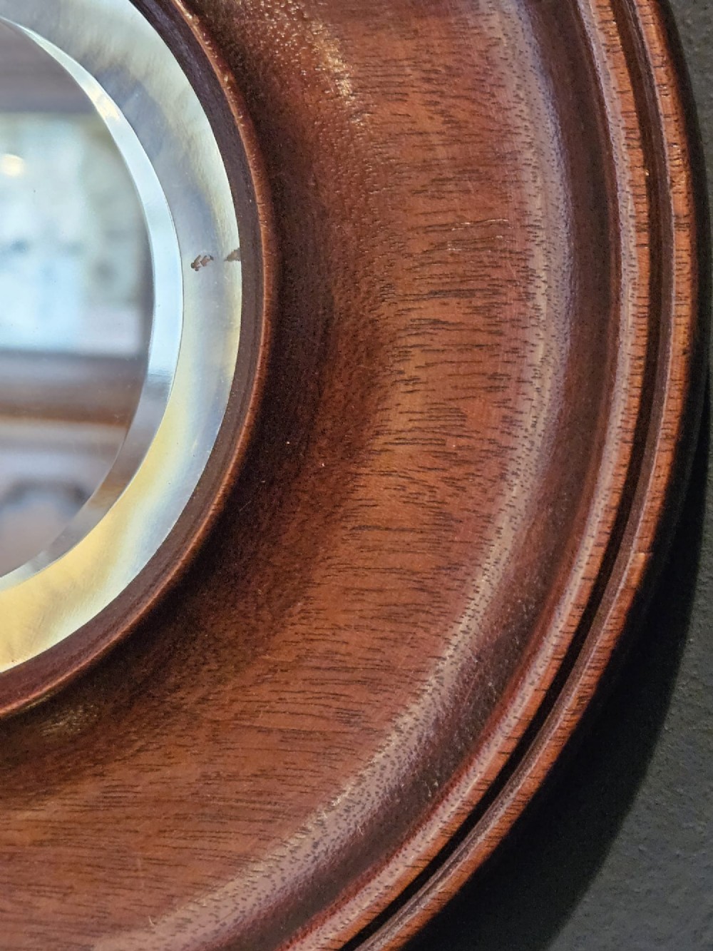 A small Victorian circular mirror featuring a turned mahogany frame with a central bevelled glass plate and top brass hanging loop. View V