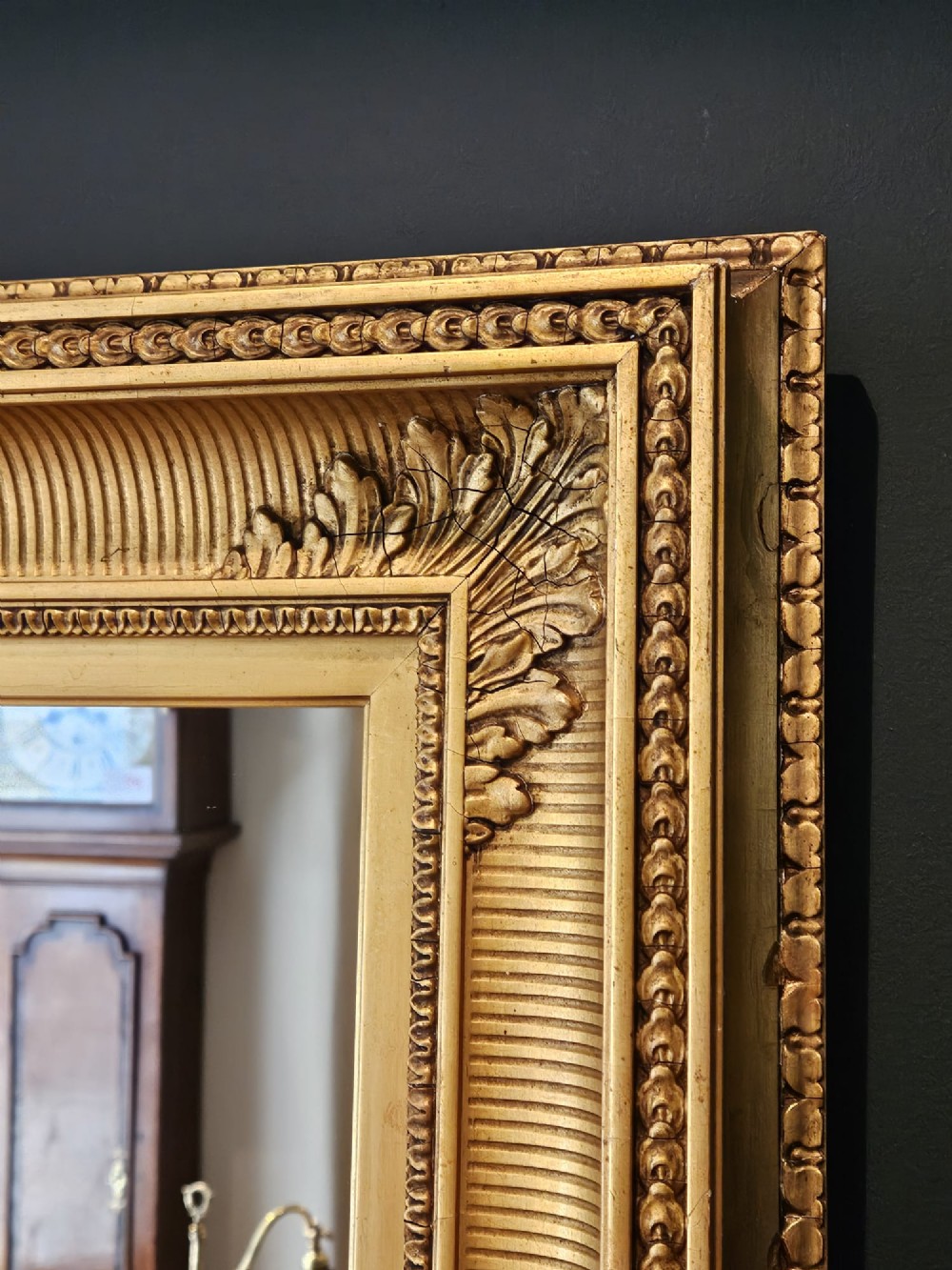 A rectangular Victorian giltwood wall mirror featuring fluted cove moulding, beaded inner borders, and raised acanthus leaf ornamentation at each corner. View II