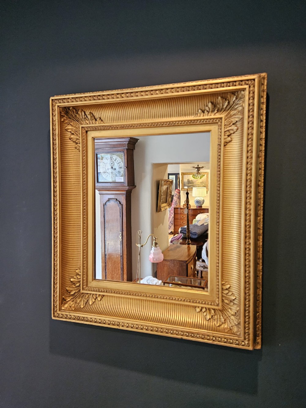 A rectangular Victorian giltwood wall mirror featuring fluted cove moulding, beaded inner borders, and raised acanthus leaf ornamentation at each corner. View IV