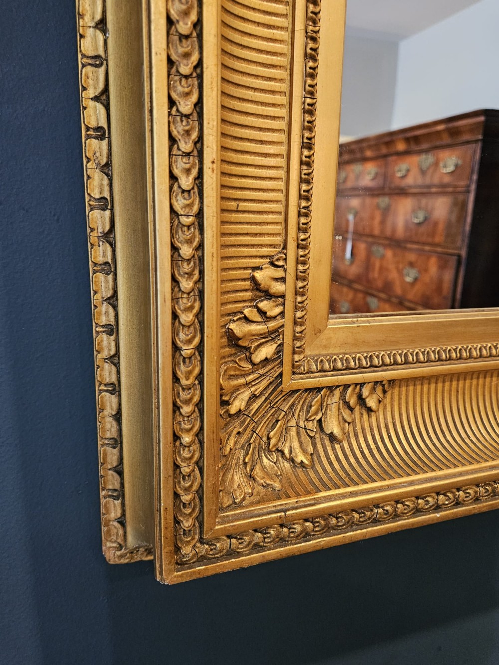 A rectangular Victorian giltwood wall mirror featuring fluted cove moulding, beaded inner borders, and raised acanthus leaf ornamentation at each corner. View V