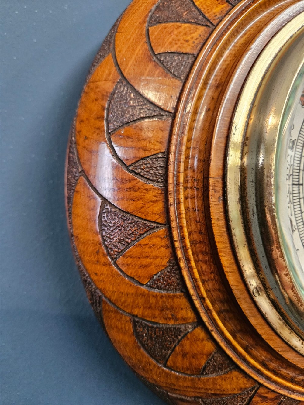 A circular Victorian aneroid wall barometer housed in a turned and carved oak case with a brass bezel. View III