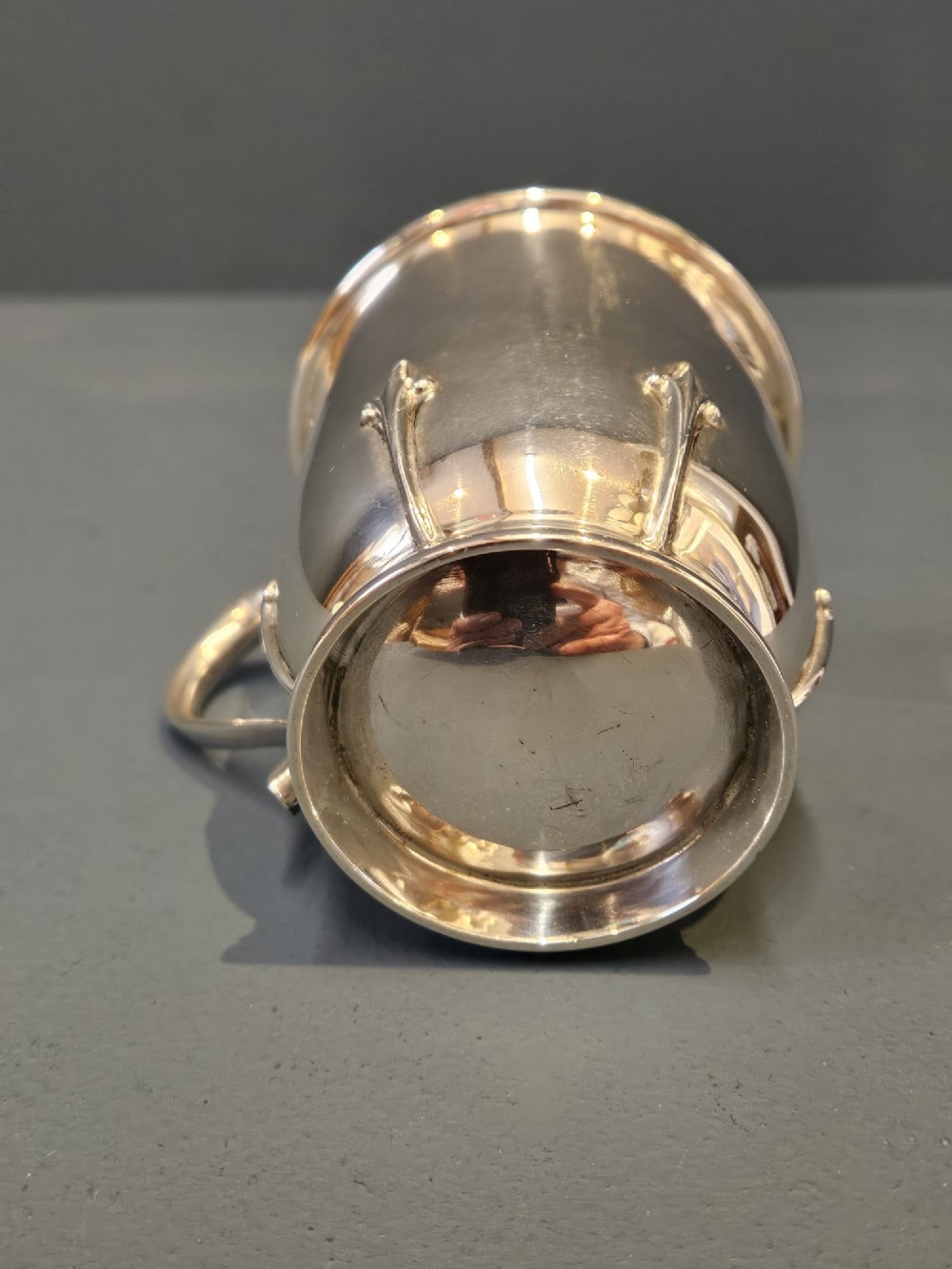 A hallmarked sterling silver mug with raised strapwork details around the lower body, a gilded interior, and a single loop handle. View III