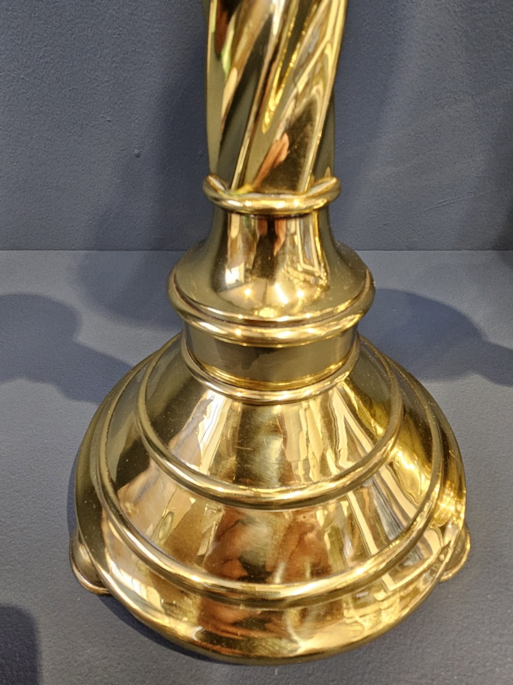A pair of tall, polished brass Victorian church candlesticks with barley twist stems, crenellated crowns, and circular stepped bases. View III