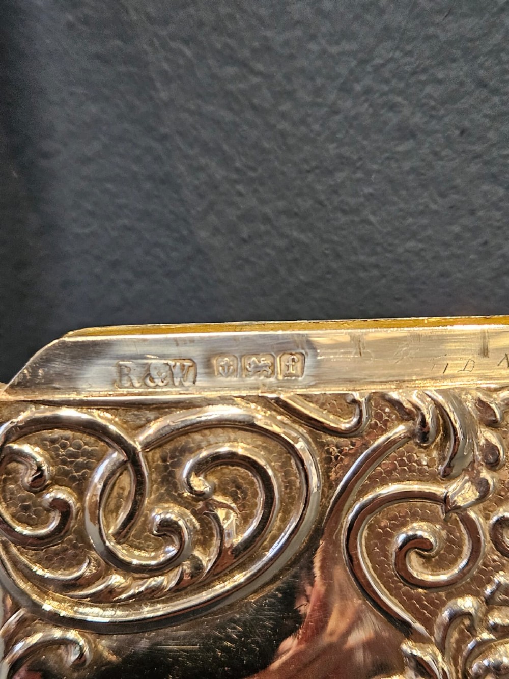 An Edwardian sterling silver hinged card case featuring intricate Art Nouveau repousse scrollwork and floral relief design. View IV