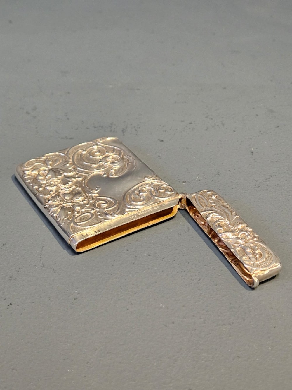 An Edwardian sterling silver hinged card case featuring intricate Art Nouveau repousse scrollwork and floral relief design. View VII