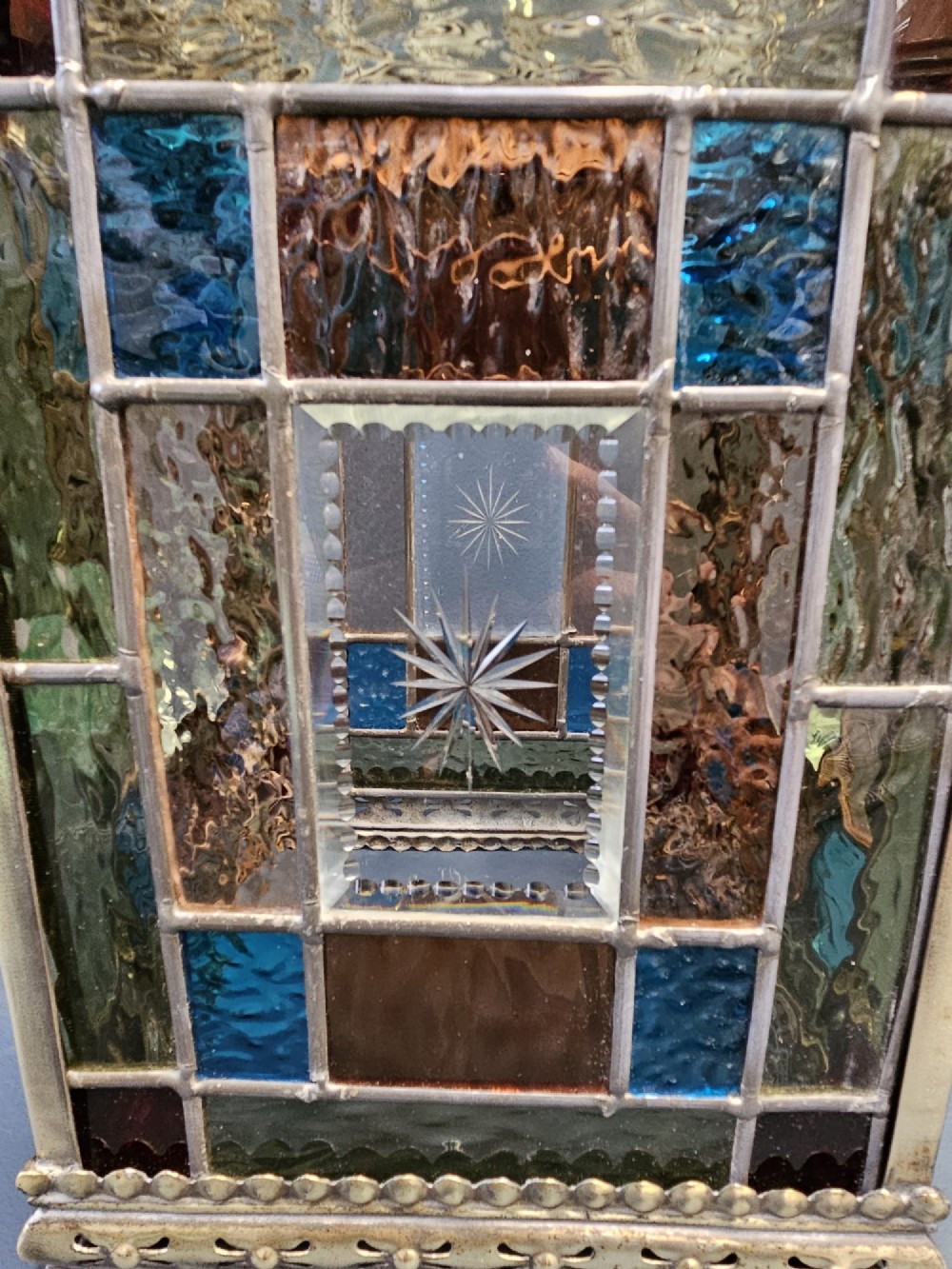 A Victorian brass hanging lantern featuring leaded stained-glass panels with starburst detailing and an ornate floral rim. View VII