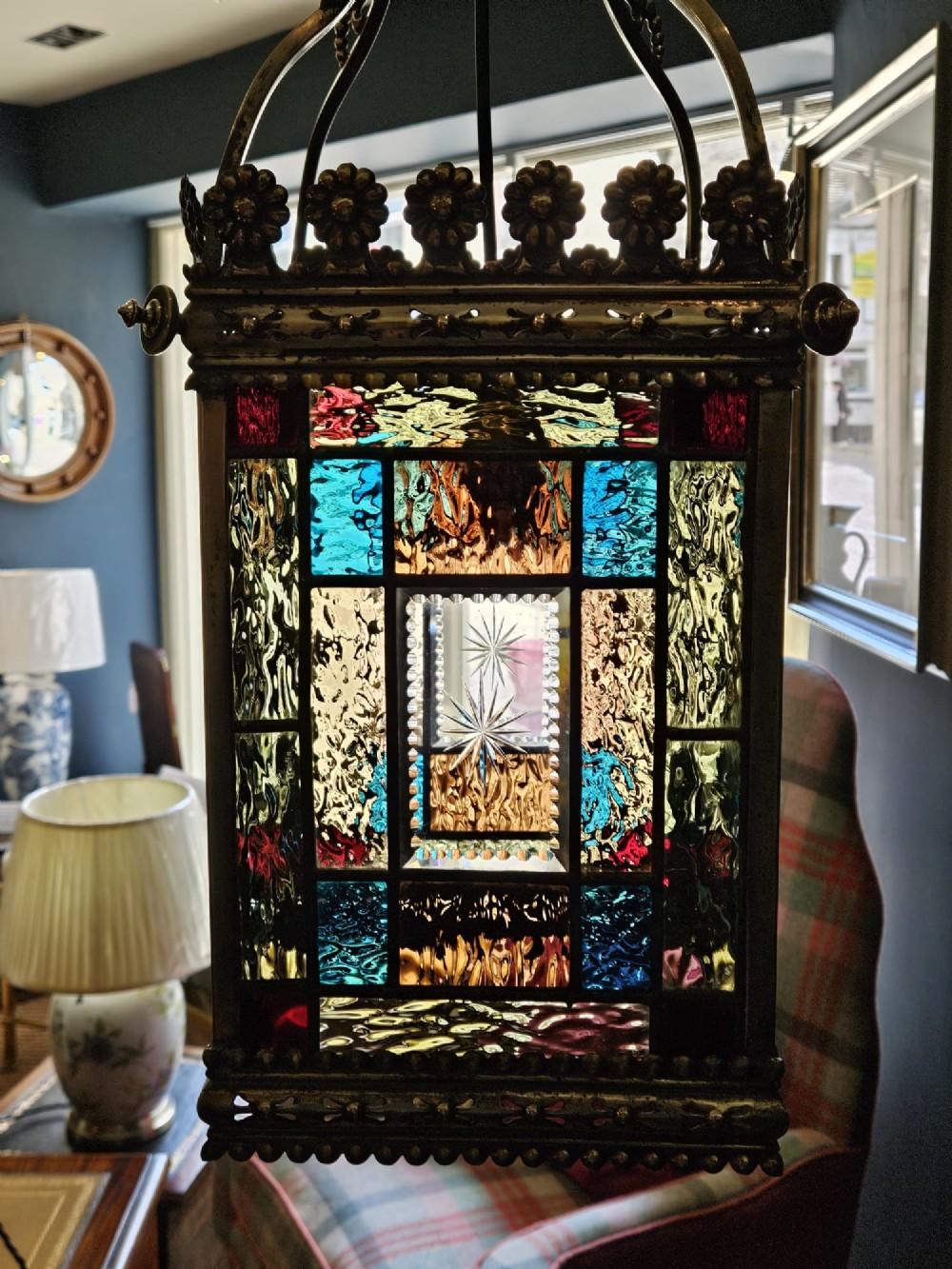 A Victorian brass hanging lantern featuring leaded stained-glass panels with starburst detailing and an ornate floral rim. View VIII