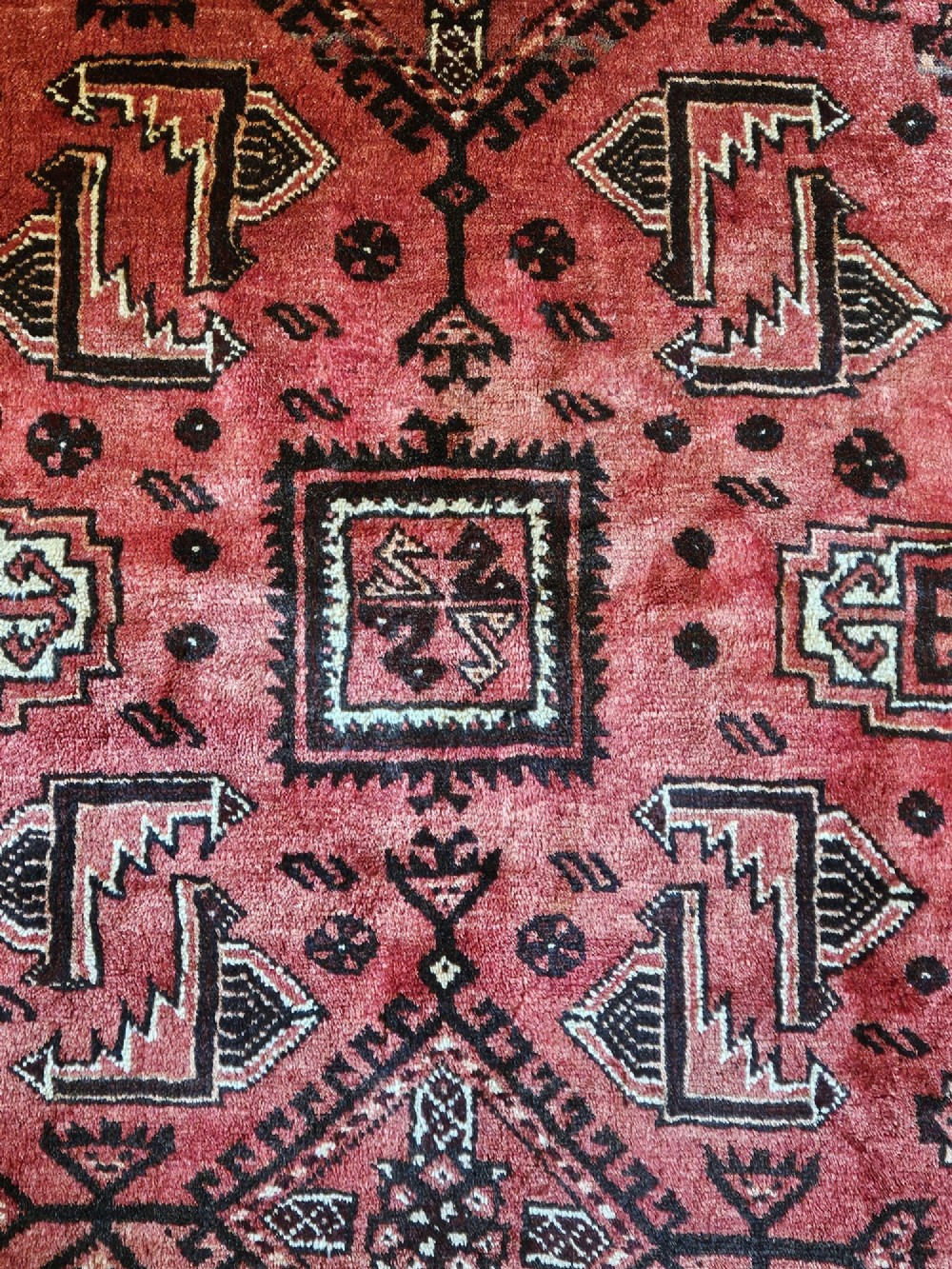 A hand-knotted deep red and dark brown Baluch tribal wool rug featuring geometric diamond medallions and short white fringe edges. View III