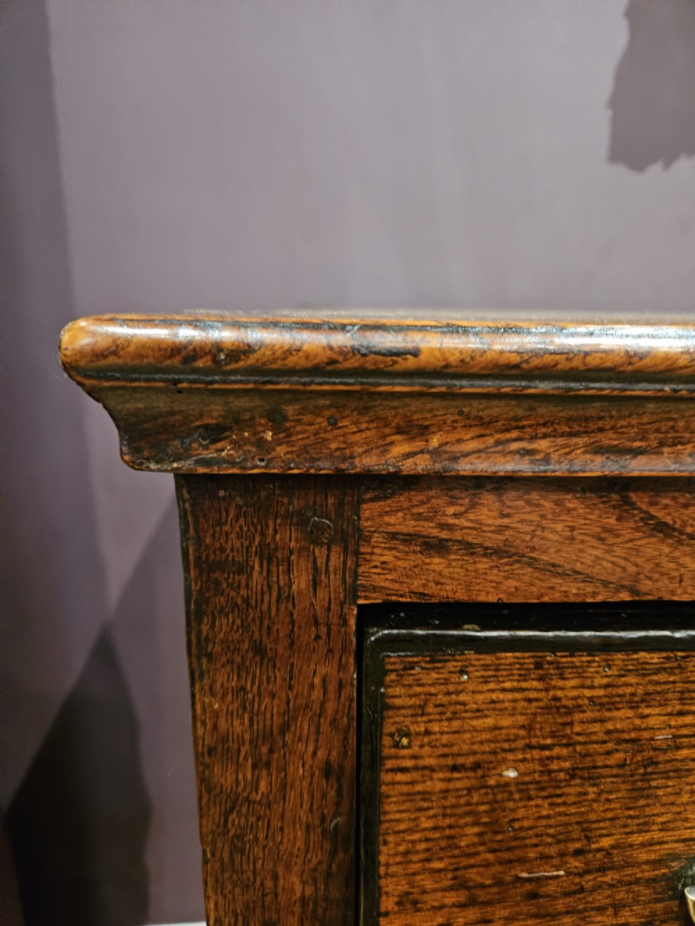 An 18th-century George II elm low dresser featuring three drawers with brass bail handles and shaped cabriole legs. View V