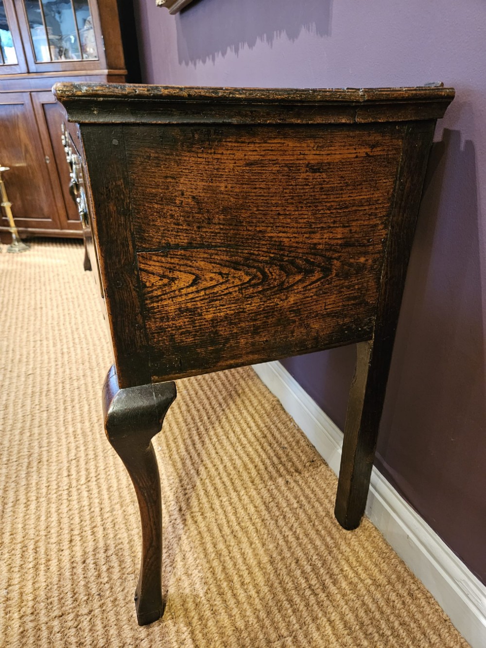 An 18th-century George II elm low dresser featuring three drawers with brass bail handles and shaped cabriole legs. View VI