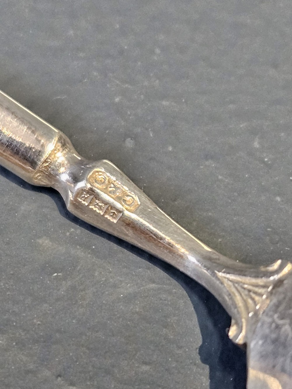 A set of six silver coffee spoons displayed inside a dark fitted presentation case lined with blue velvet and white silk. View II